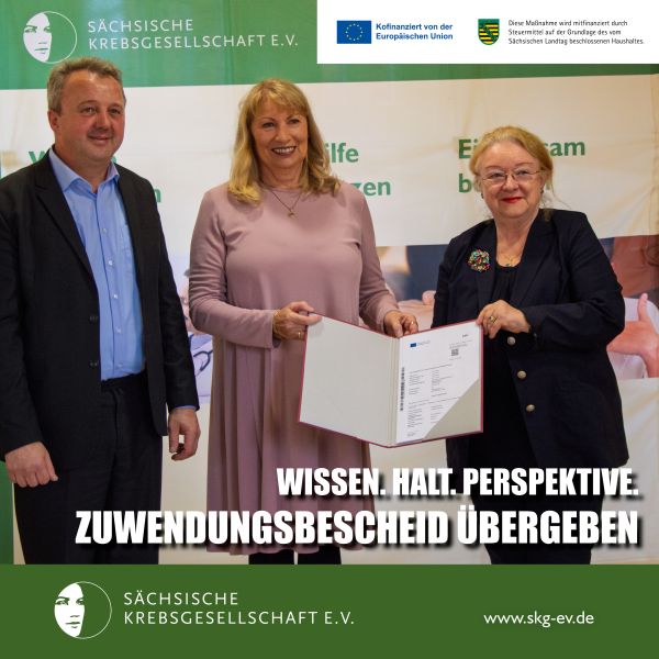 Drei Personen bei der Übergabe eines Zuwendungsbescheids